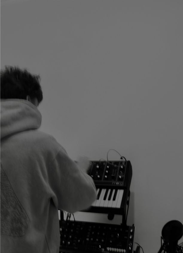 Boy in-front of a synth playing it
